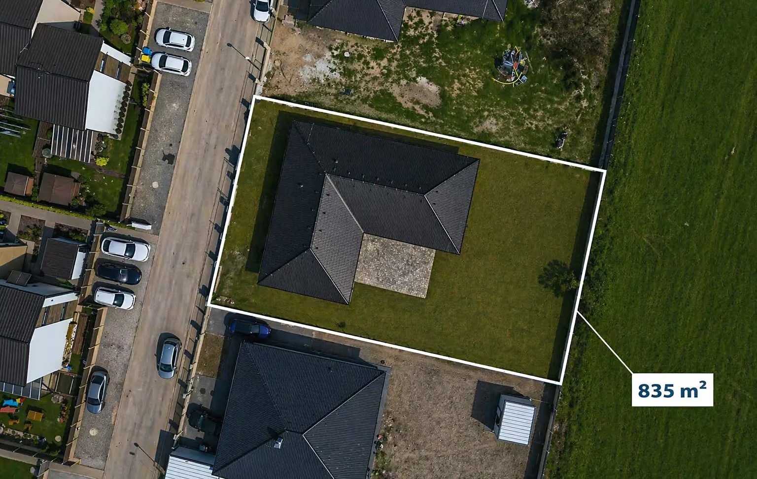 Letecký snímek pozemku s vyznačenou hranicí, 835 m²